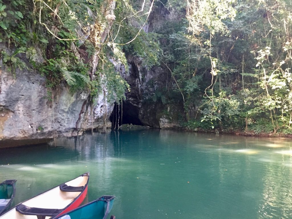 Canoes at the entrance to cave on a river.