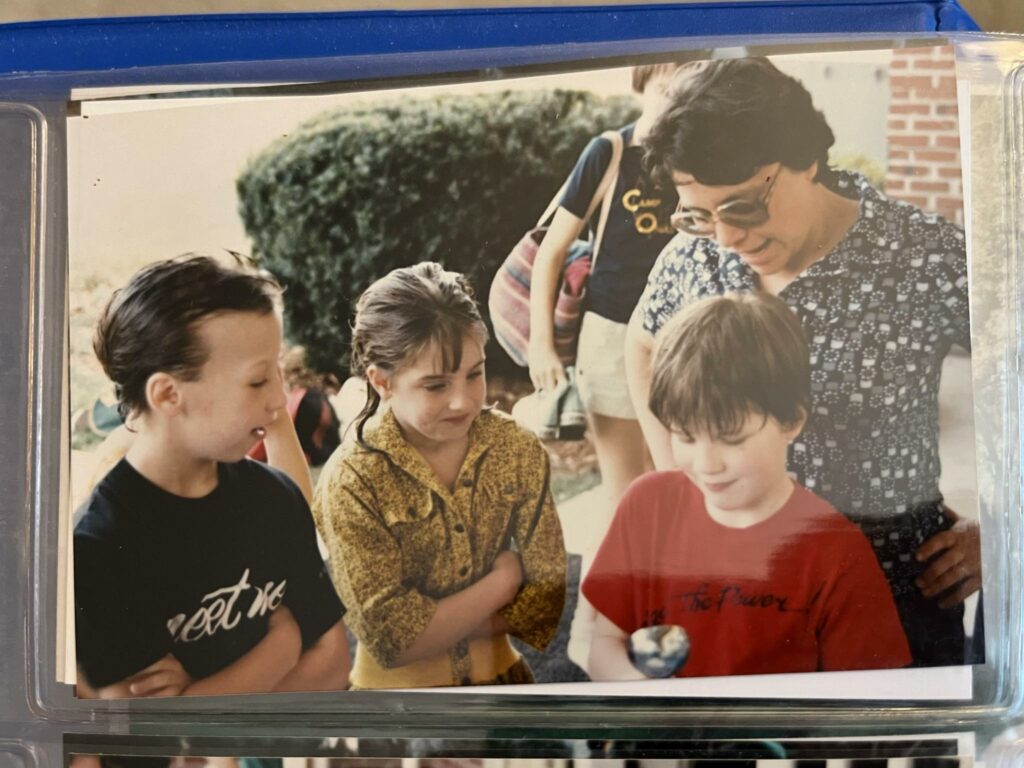 A picture of a picture, featuring my mother and a few friends watching me as I'm about to cut a birthday cake.