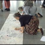Two women kneeling to sign the banner against nuclear weapons on the Balkins.